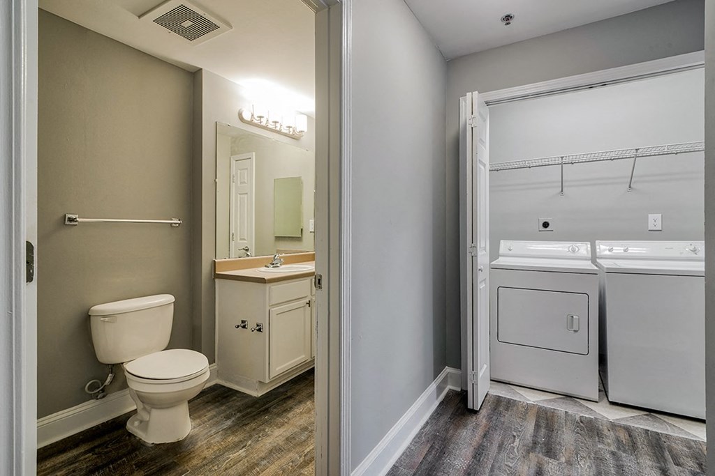 a bathroom with a toilet and a washer and dryer
