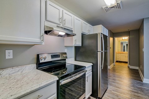 A kitchen with a stove top oven and a refrigerator.