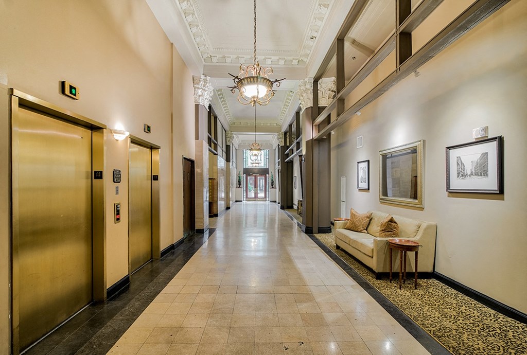 a large hallway with a chandelier and a couch