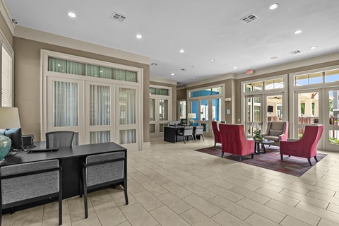 A spacious office with a desk, chairs, and a large window.