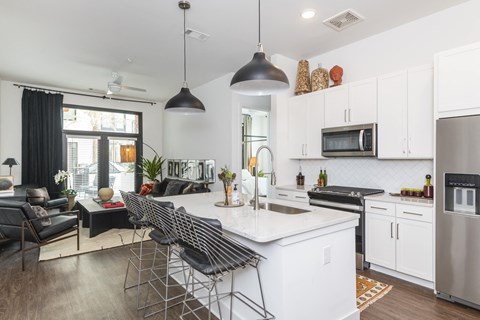 A modern kitchen with a white island and stainless steel appliances.