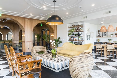 A living room with a yellow sofa and a black and white checkered floor.