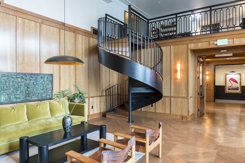 A spiral staircase in a room with wooden walls and floors.