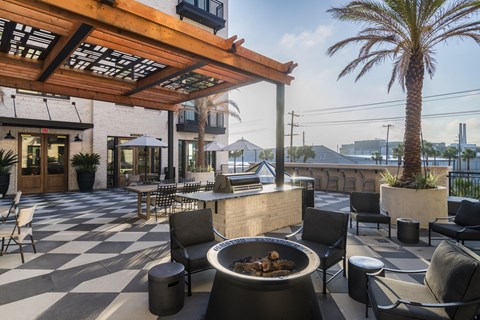 A patio with a fire pit and chairs.