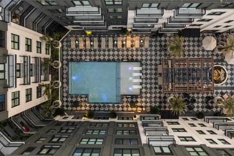 A modern building with a pool and a black and white checkered wall.