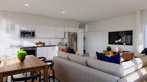 A modern kitchen with a dining table and a grey couch.