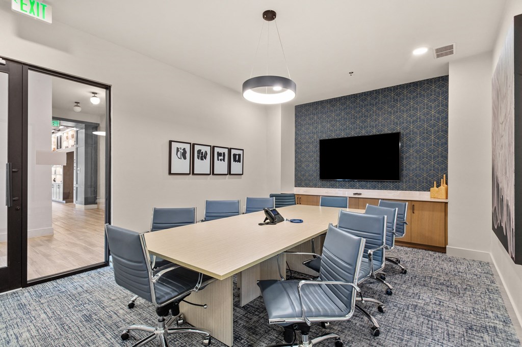 a conference room with a long table and chairs and a tv
