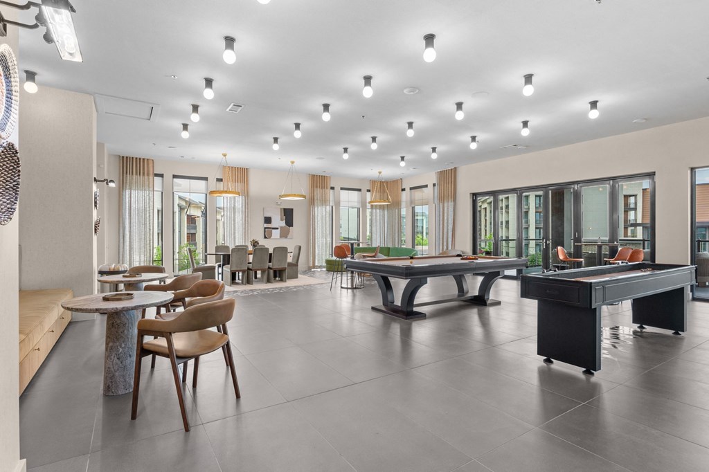 a large room with a pool table and tables in it
