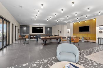 a clubhouse with a pool table and chairs and a television