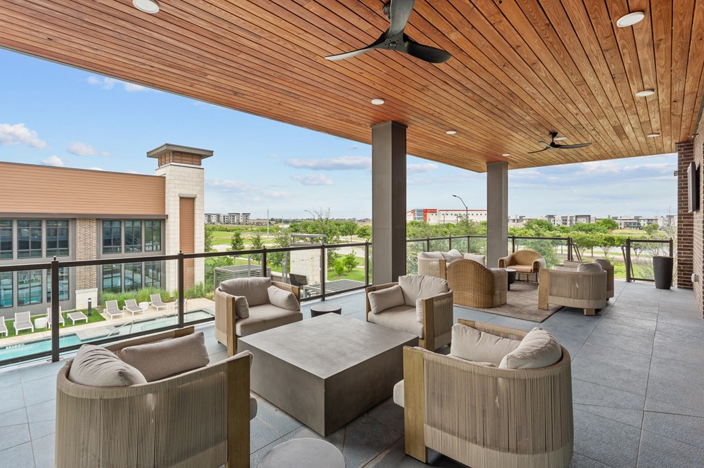 the lobby of a hotel with couches and chairs and a balcony