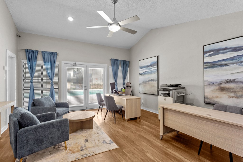A living room with a grey sofa, a wooden table, and a painting on the wall.