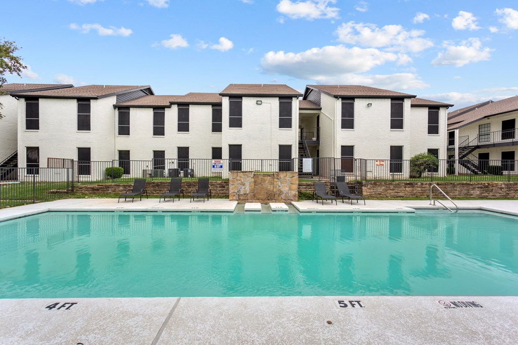 A swimming pool in front of a building with the number 411 on it.