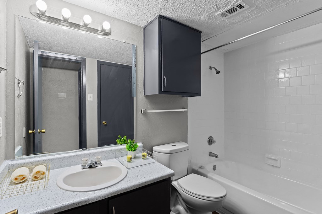 A bathroom with a sink, toilet, and bathtub.