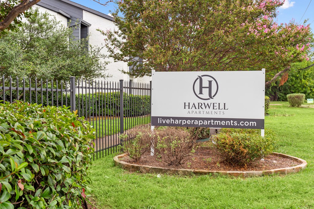 A sign for Harwell Apartments is displayed in front of a building.