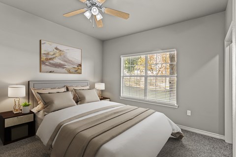 A bedroom with a large bed and a ceiling fan.