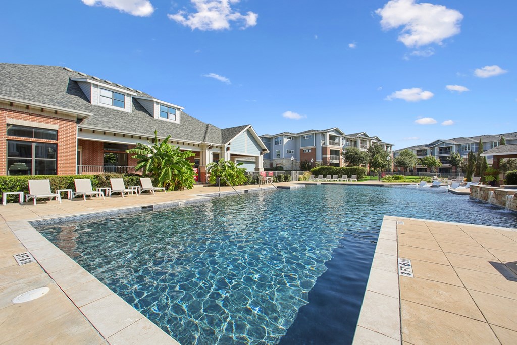 A swimming pool in a residential area with houses in the background.