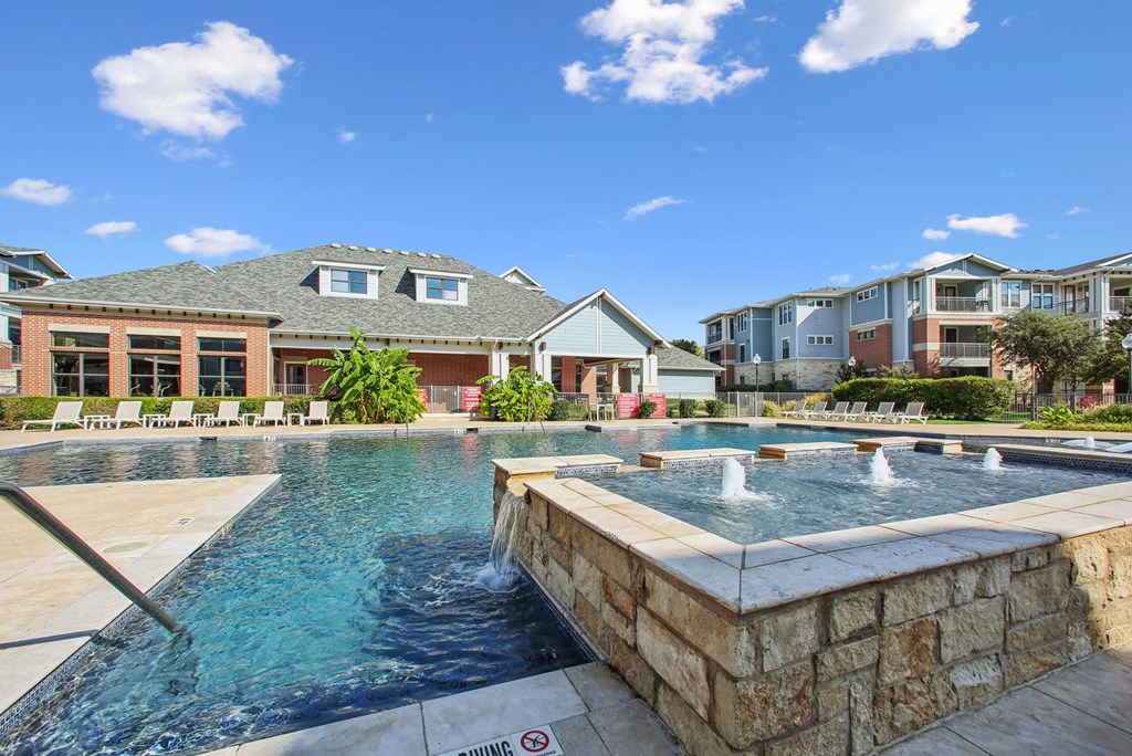 A pool with a waterfall and a sign that says "Swimming".