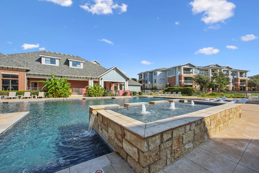 A swimming pool with a waterfall in the middle of it.