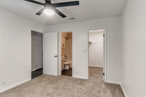 A room with a ceiling fan and carpeted floor.