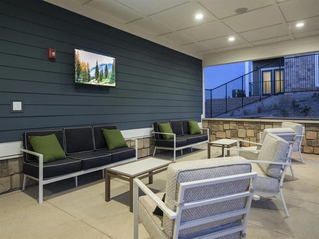 a patio with chairs and tables and a television on the wall