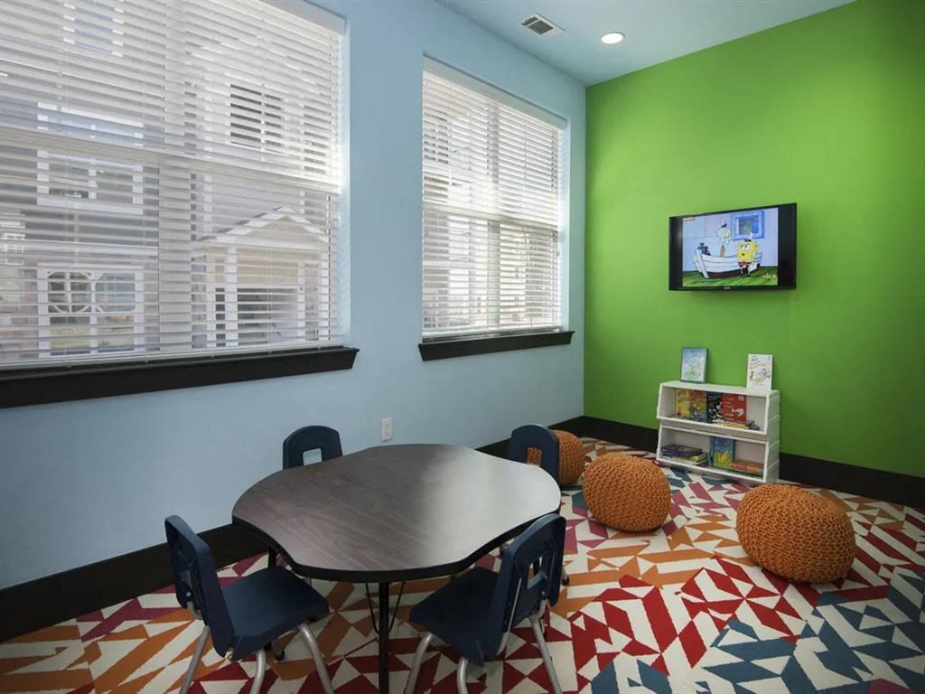 a play room with a table and chairs and a television