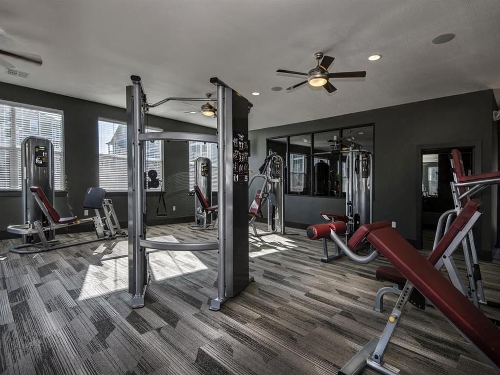 a gym with weights and a ceiling fan