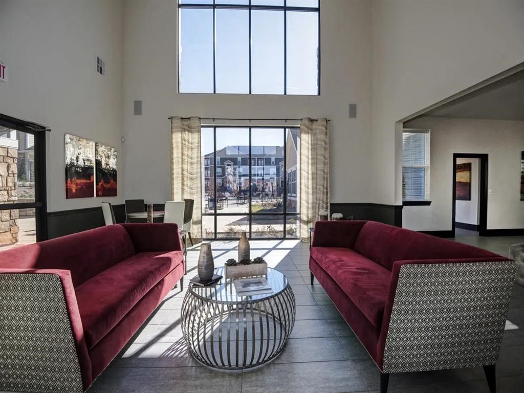a living room with two red couches and a glass table