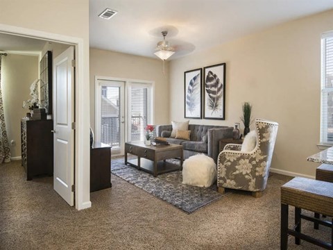 a living room with furniture and a door to a balcony