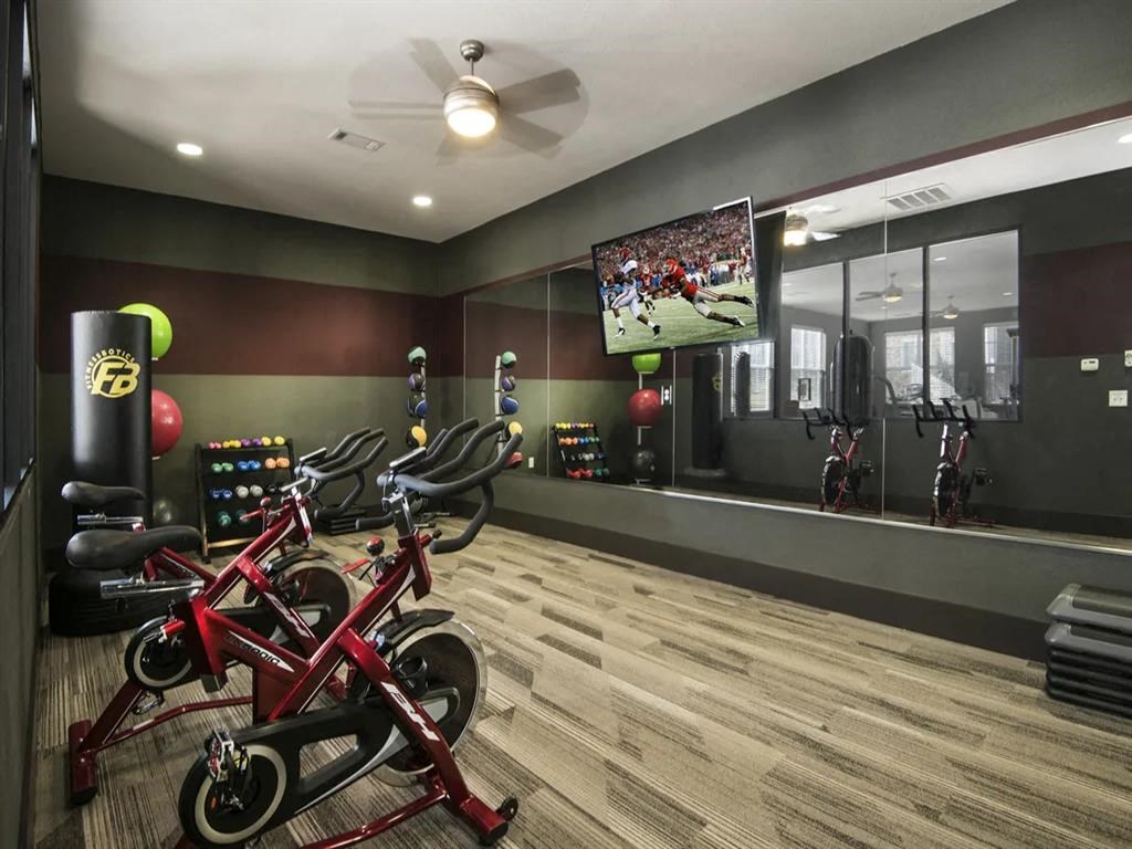 a home gym with bikes and a tv