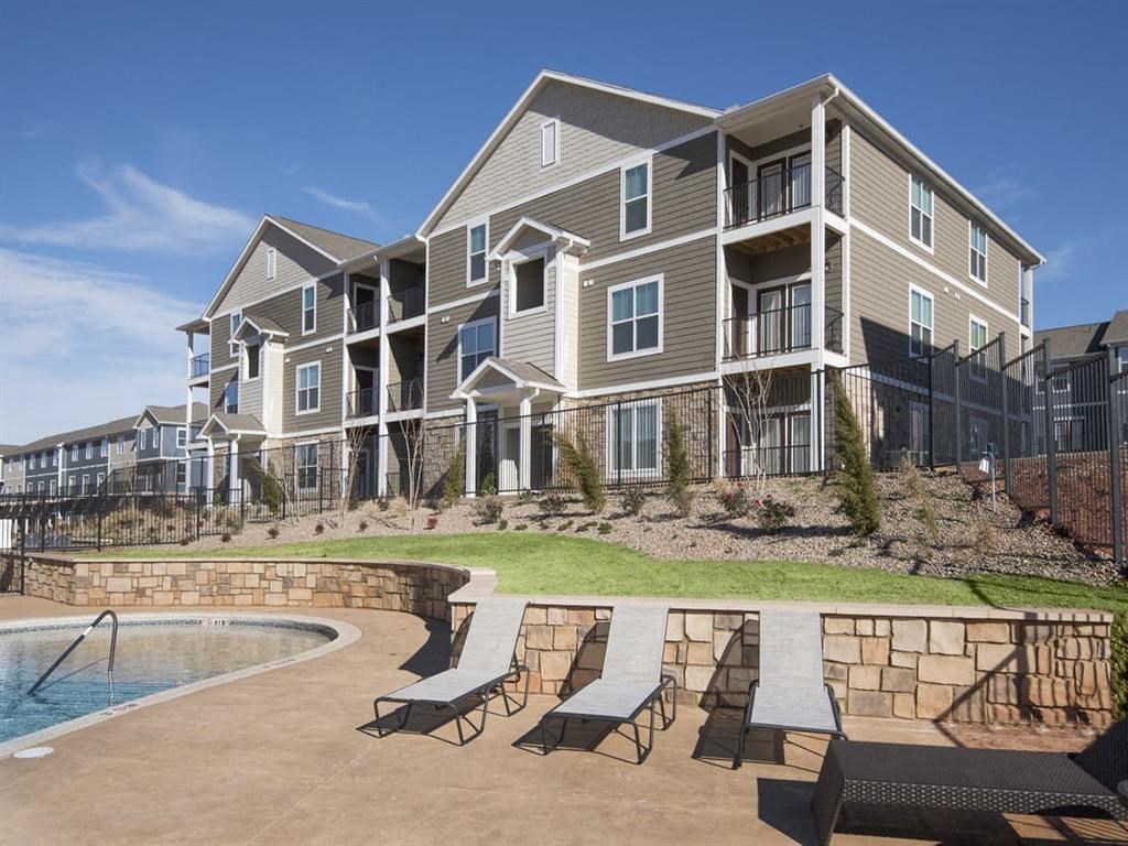 an apartment building with a swimming pool in front of it