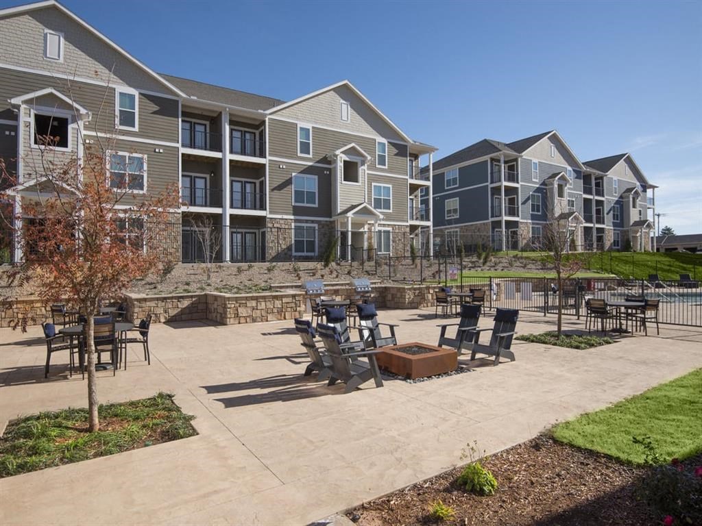 an outdoor patio with tables and chairs at an apartment complex
