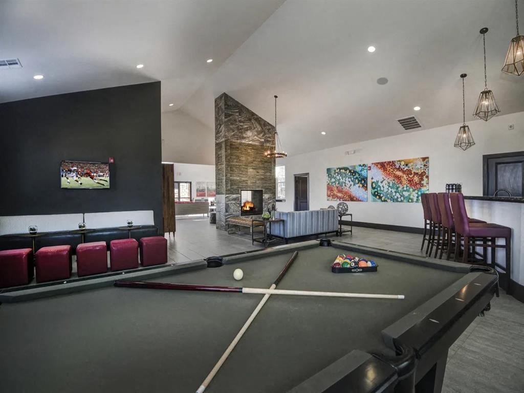 a game room with a pool table and a fireplace
