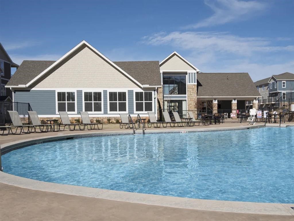 a swimming pool with a house in the background