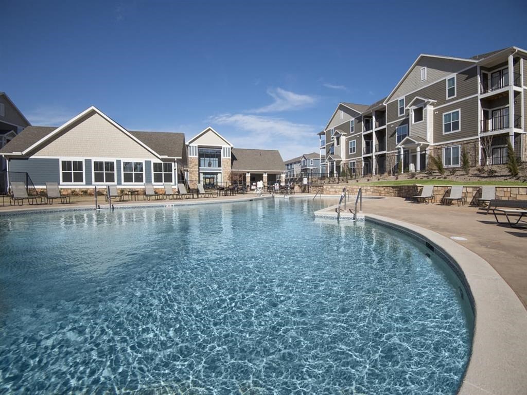 a large pool with an apartment building in the background