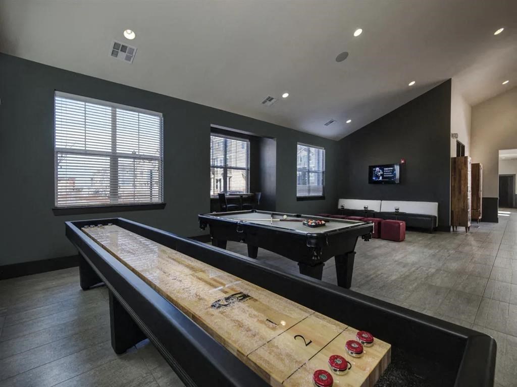 a game room with two pool tables and a tv