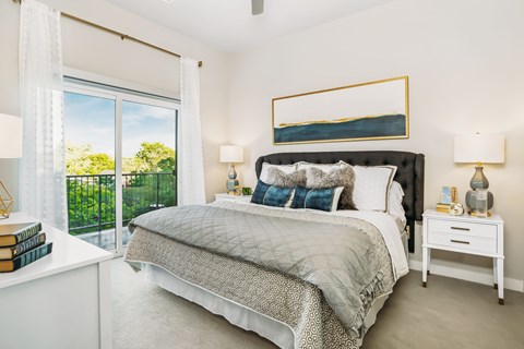 A bedroom with a large bed and a painting above it.