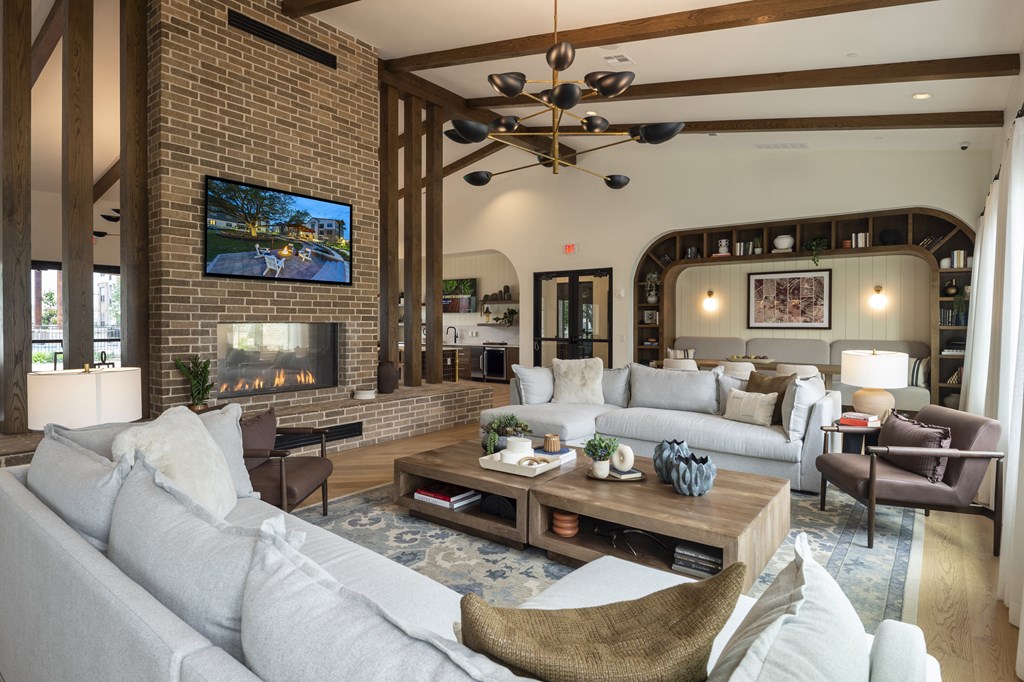 A living room with a grey couch and a television on the wall.