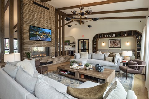 A living room with a grey couch and a television on the wall.