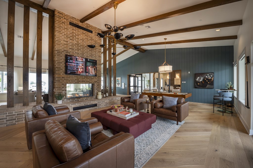 A living room with a brick fireplace and a large couch.
