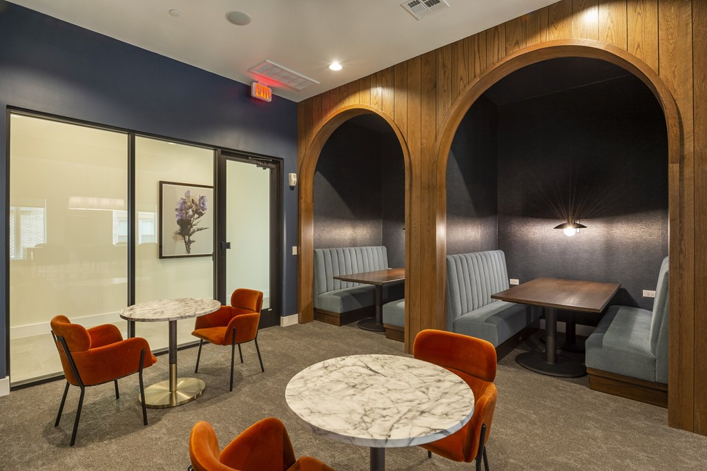 A room with a table surrounded by chairs.