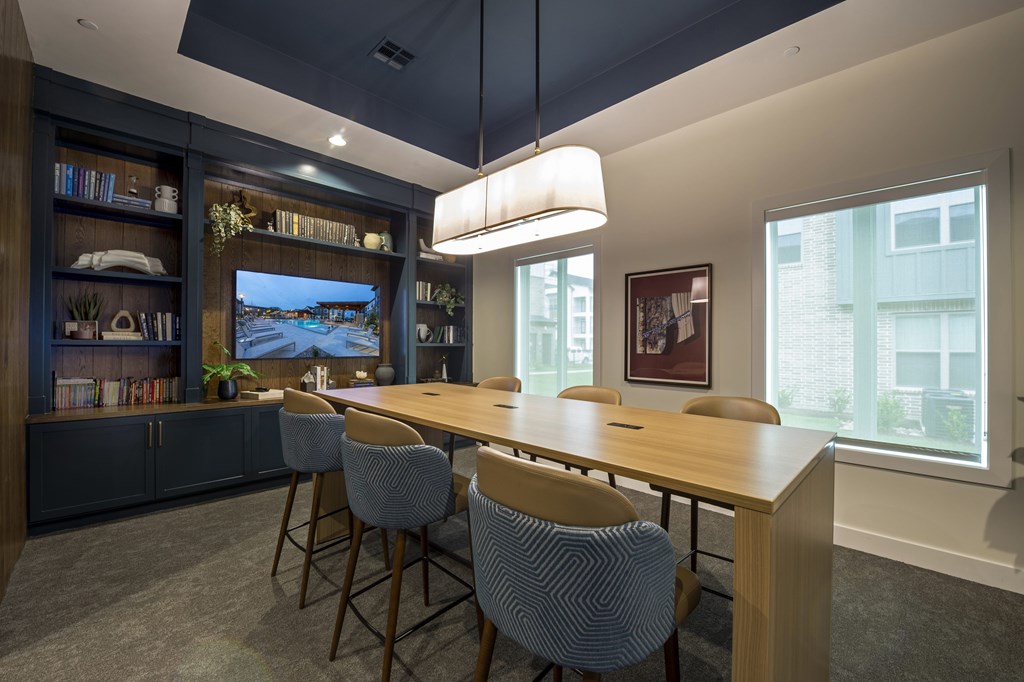 A conference room with a long table and chairs.