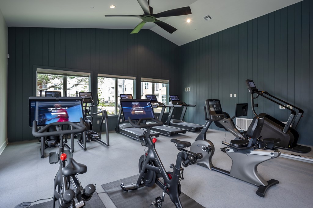A room with a ceiling fan and exercise equipment.