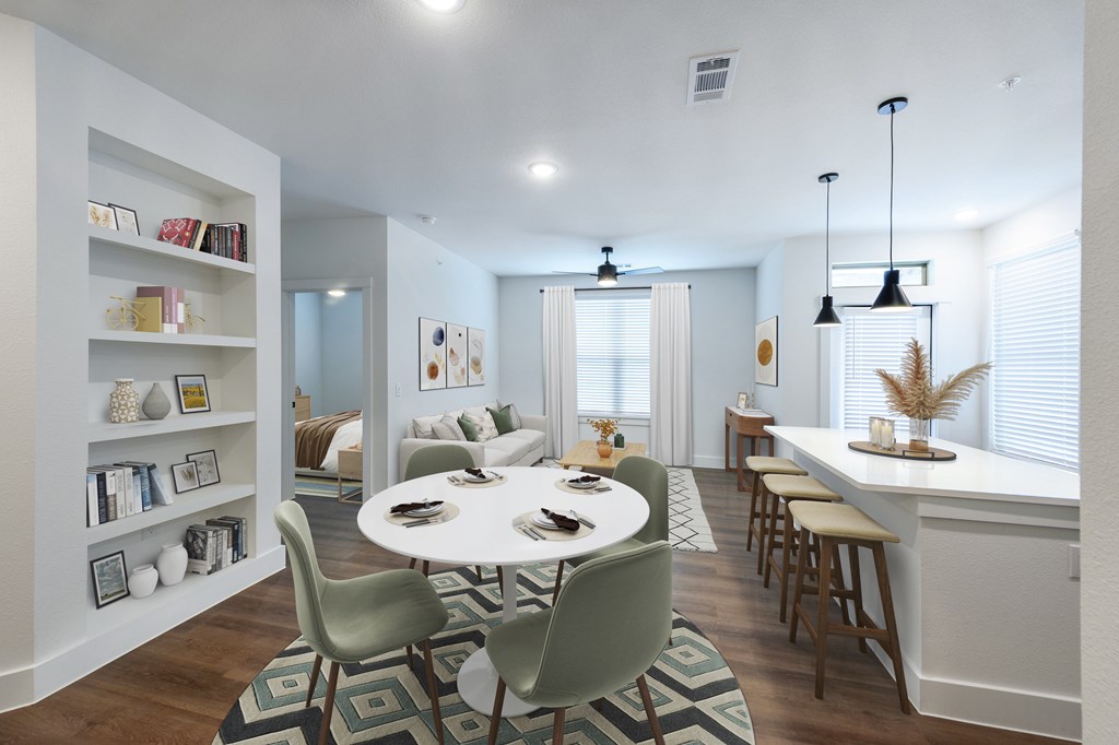 A modern dining room with a white table and green chairs.