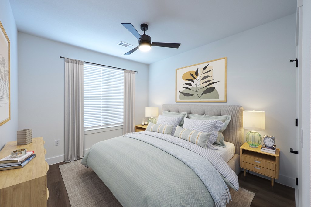 A bedroom with a large bed and a ceiling fan.