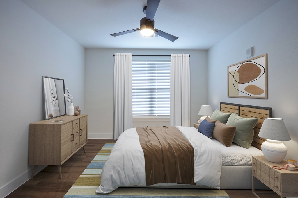 A bedroom with a bed, nightstand, and a ceiling fan.