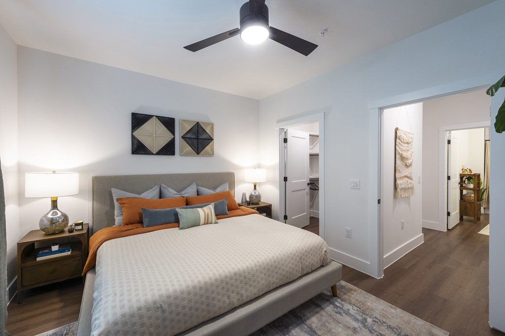 A bedroom with a large bed and a ceiling fan.