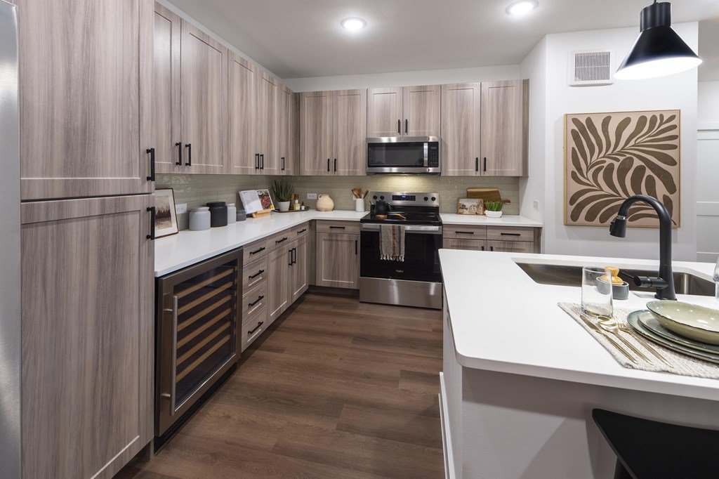 A modern kitchen with wooden cabinets and a white countertop.