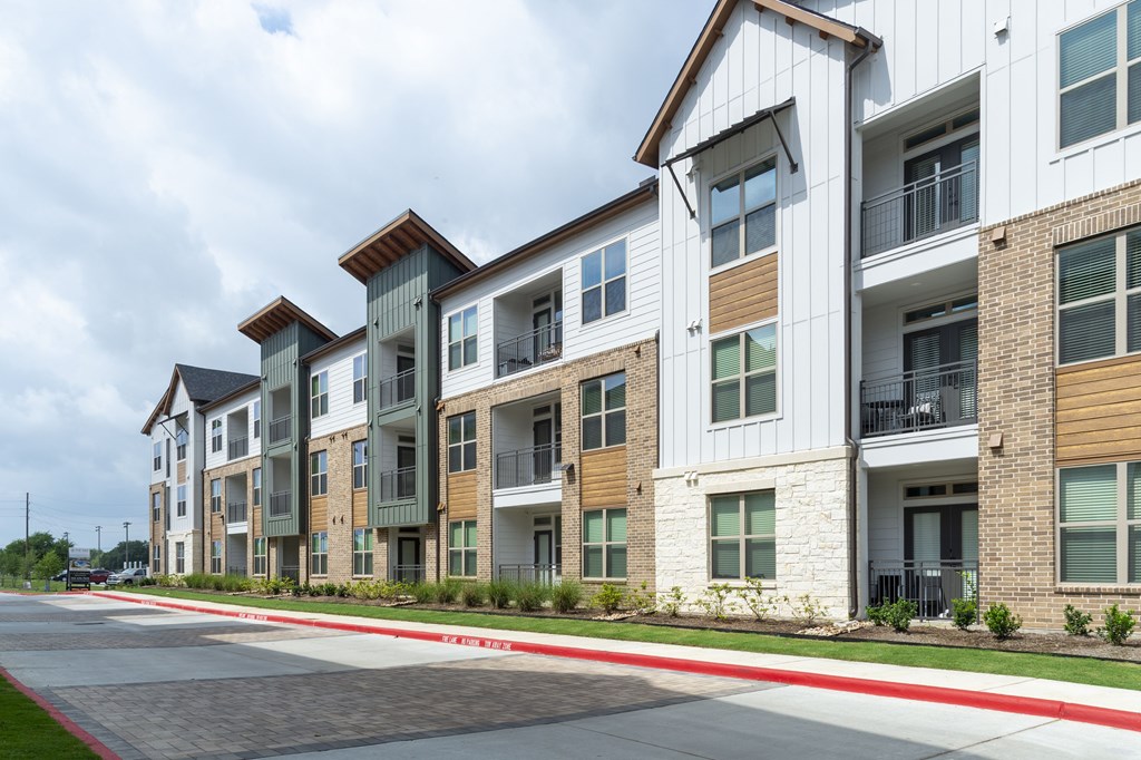 A row of modern apartment buildings with balconies and multiple windows.