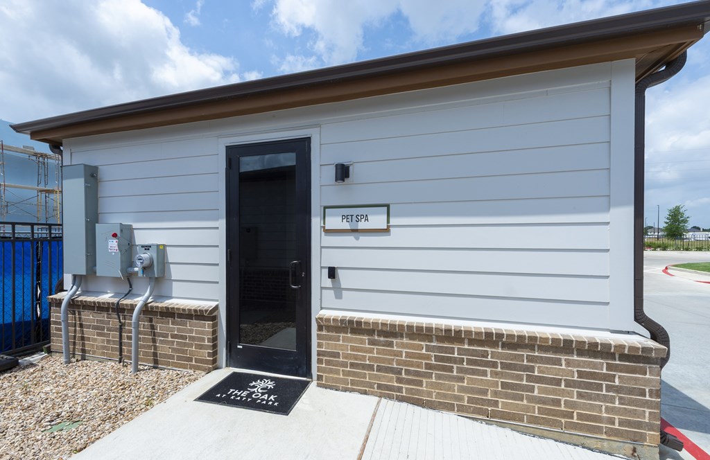 A small building with a black door and a sign that says