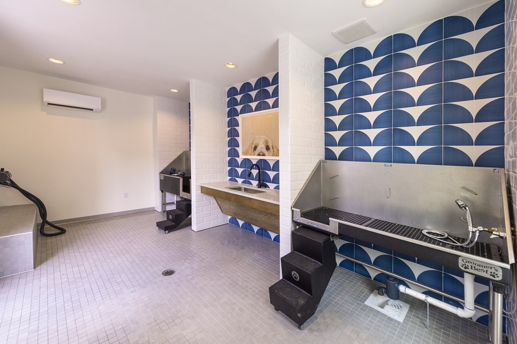 A kitchen with a blue tile backsplash and a stainless steel sink.
